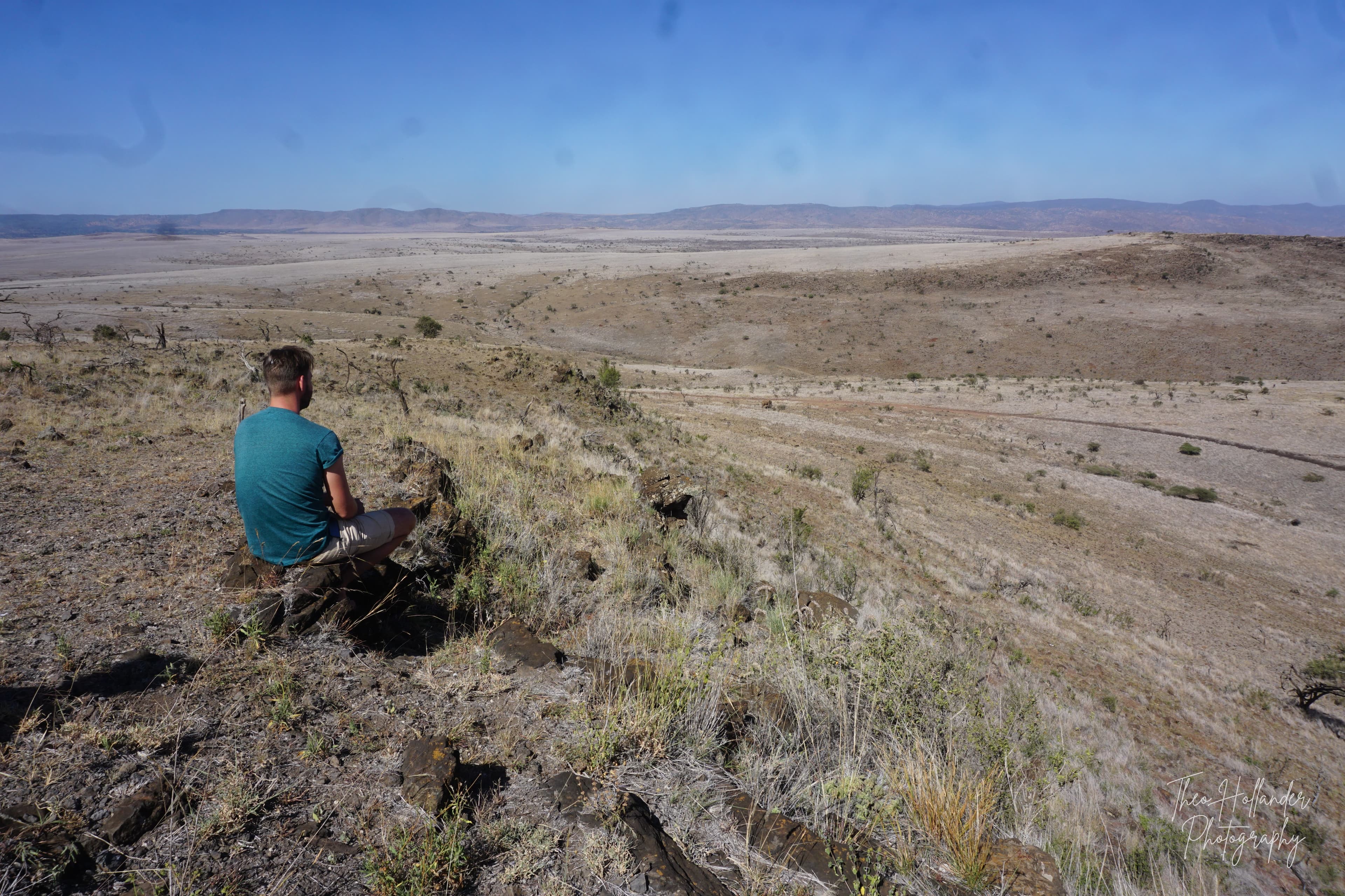 A traveller looking out over a vast desert valley