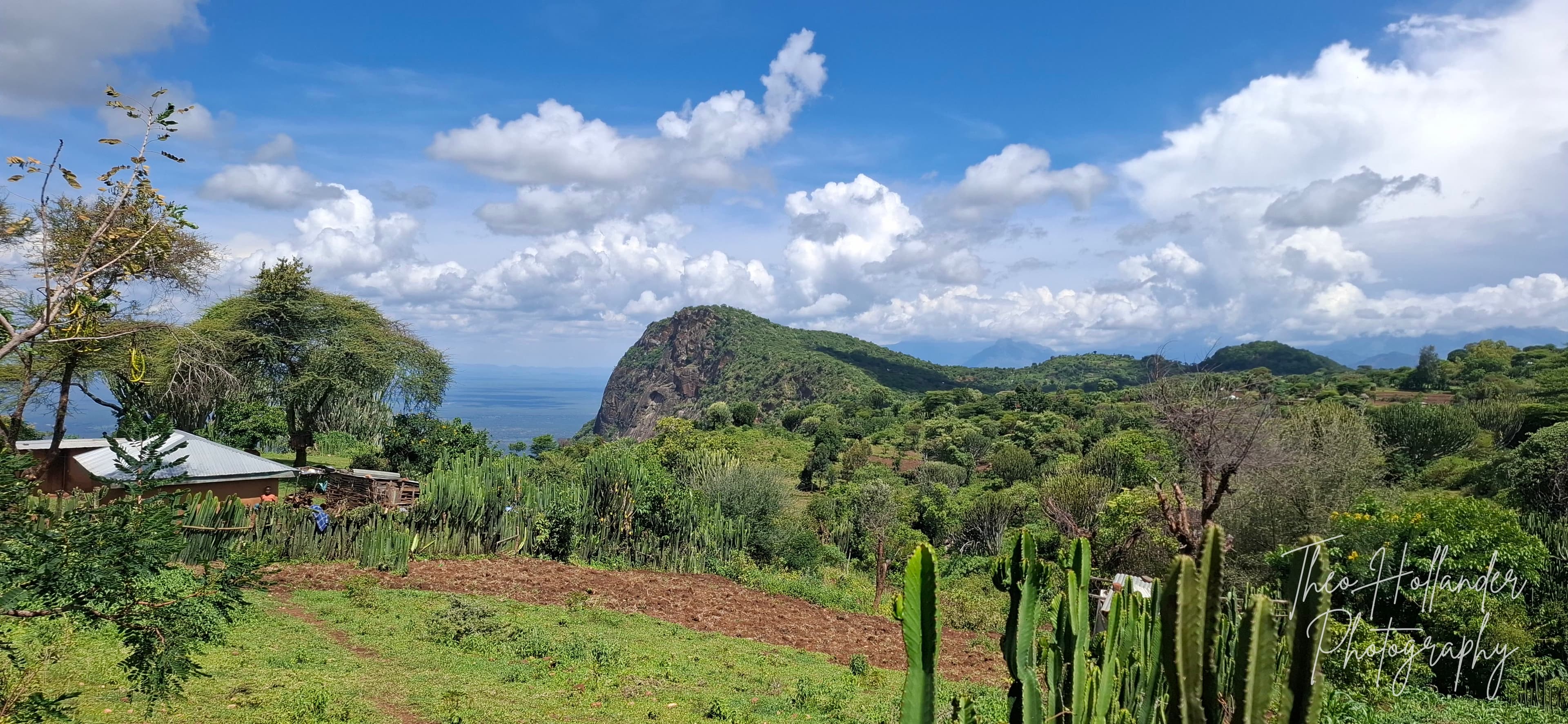 A rocky peak rising above a lush green valley