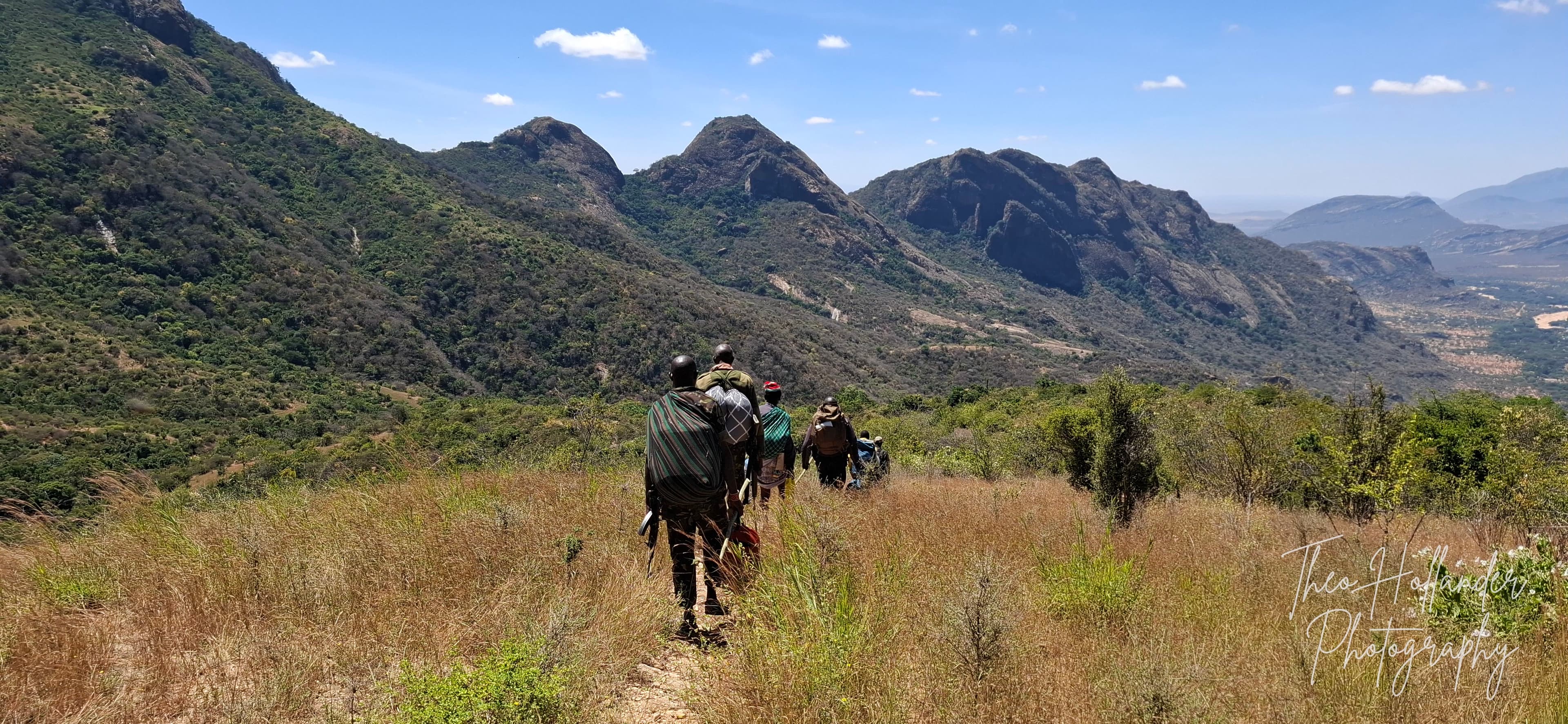 Porters and guides trekking across open grassland