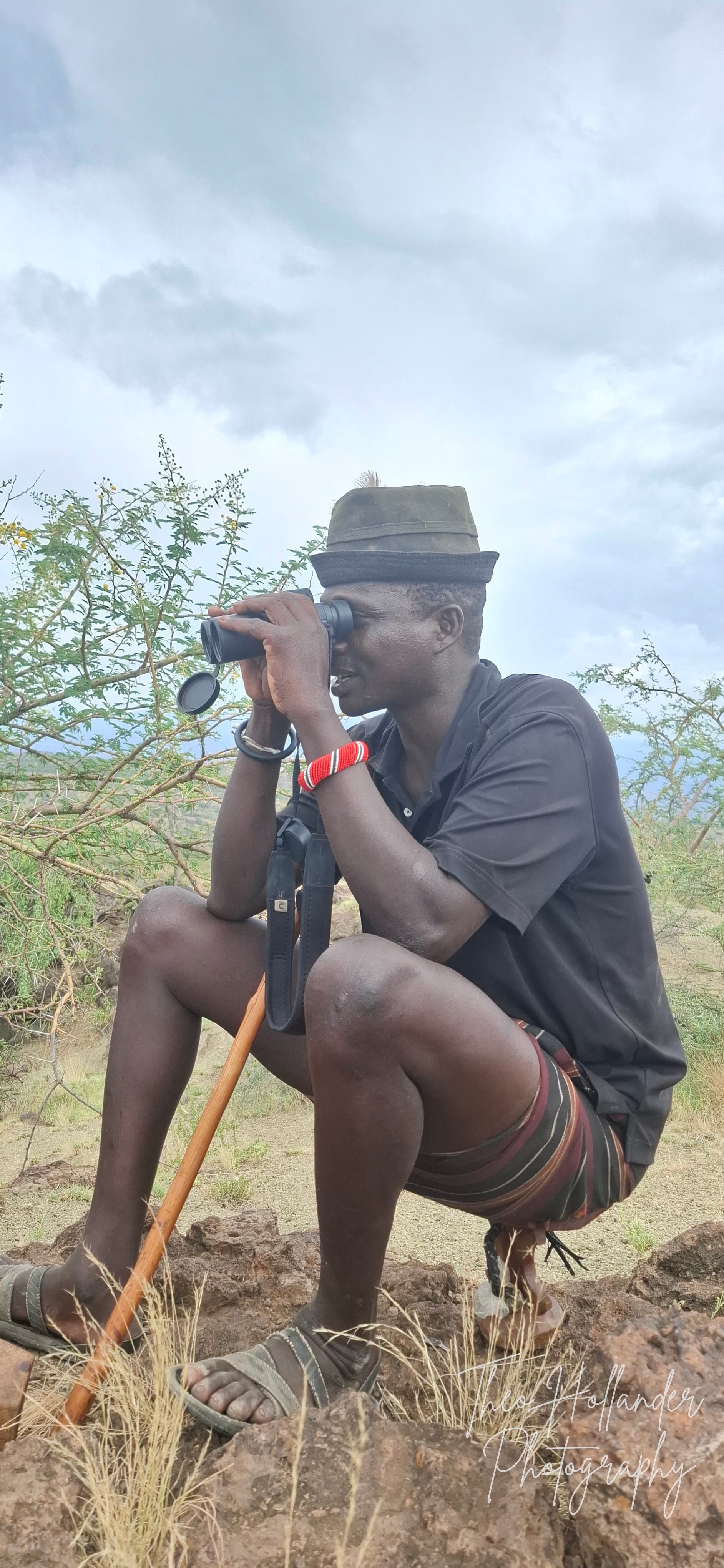 A Samburu scout scanning the horizon with binoculars